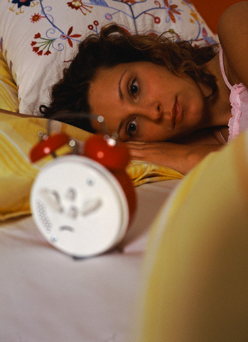 Young woman lying in bed Espaço Kaizen