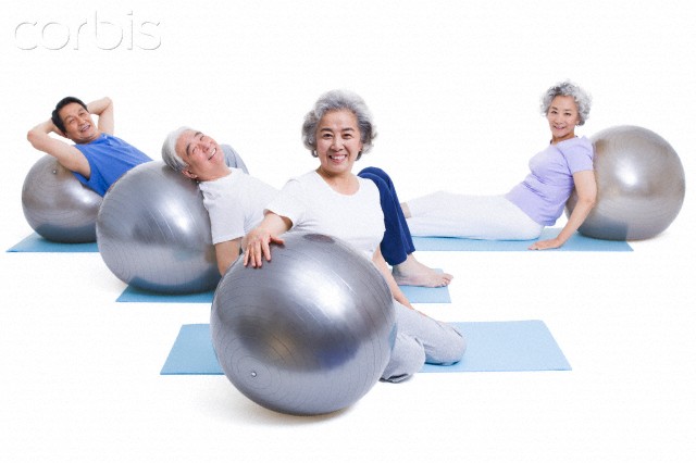 pessoas idosas treinando em bola suíça - diferenças entre artrite e artrose. Foto: Corbis