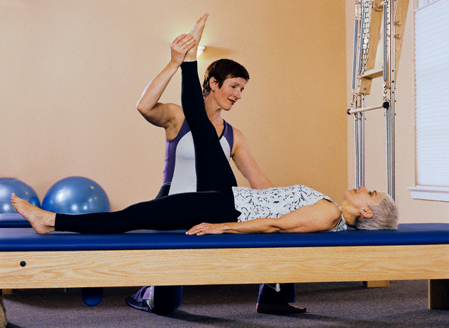 Mulher fazendo Pilates com personal trainer no reformer - ht pilates blog- pilates e fibromialgia