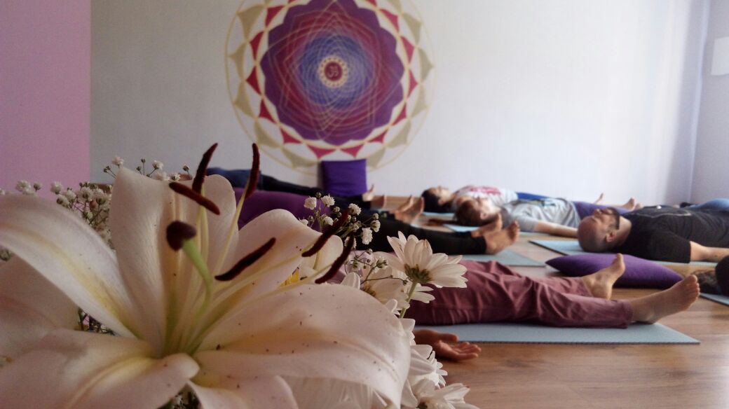 Aula de Yoga com pessoas deitadas meditando