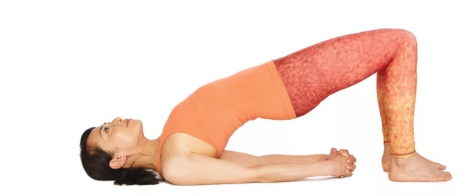 mulher de blusa laranja e calça vermelha realizando setu bhadda