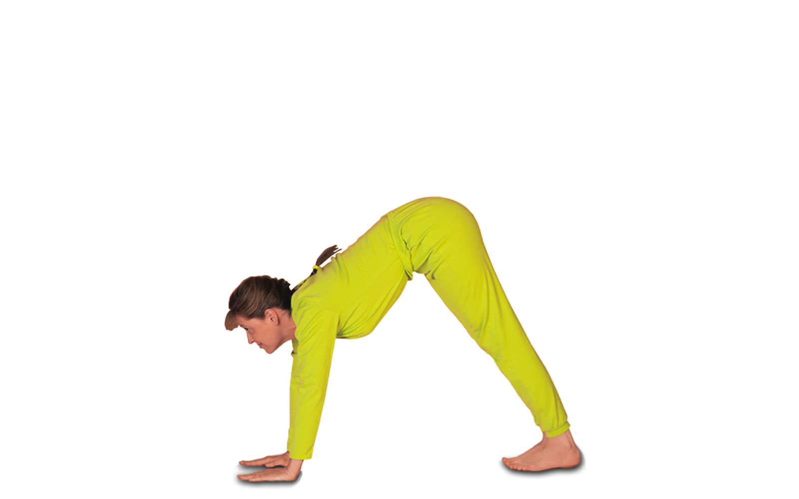 mulher de macacão amarelo, cabelos presos em trança caídos nas costas e franja com pernas esticadas, braços esticados e mãos no chão, quadril elevado, cabeça olhando para frente. Funso branco.