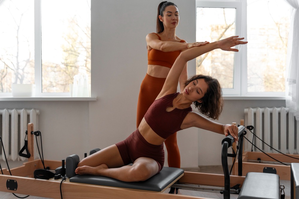 Pessoa praticando Pilates em um espaço tranquilo com aparelhos específicos.