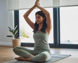 Mulher praticando yoga em um ambiente iluminado e tranquilo, representando a busca por equilíbrio e as aulas de yoga no Alto da Boa Vista.