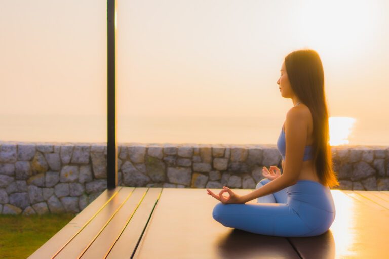 Pessoa em postura de meditação em um ambiente calmo e iluminado, representando a busca pelo equilíbrio integrativo e clareza mental através da yoga e meditação.