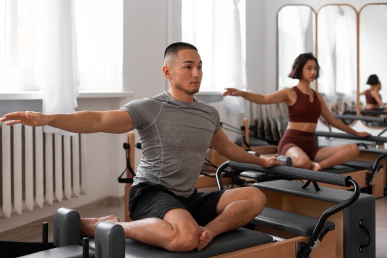 Atleta com roupas esportivas realizando exercício de fortalecimento e flexibilidade no equipamento Reformer durante uma sessão de Pilates